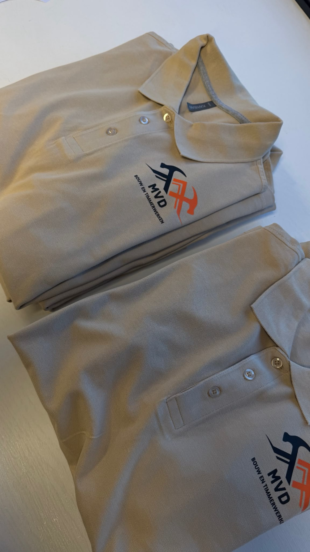 Zandkleurige polo's met MVD Bouw en Timmerwerken logo bedrukt door VA Printworks Breda